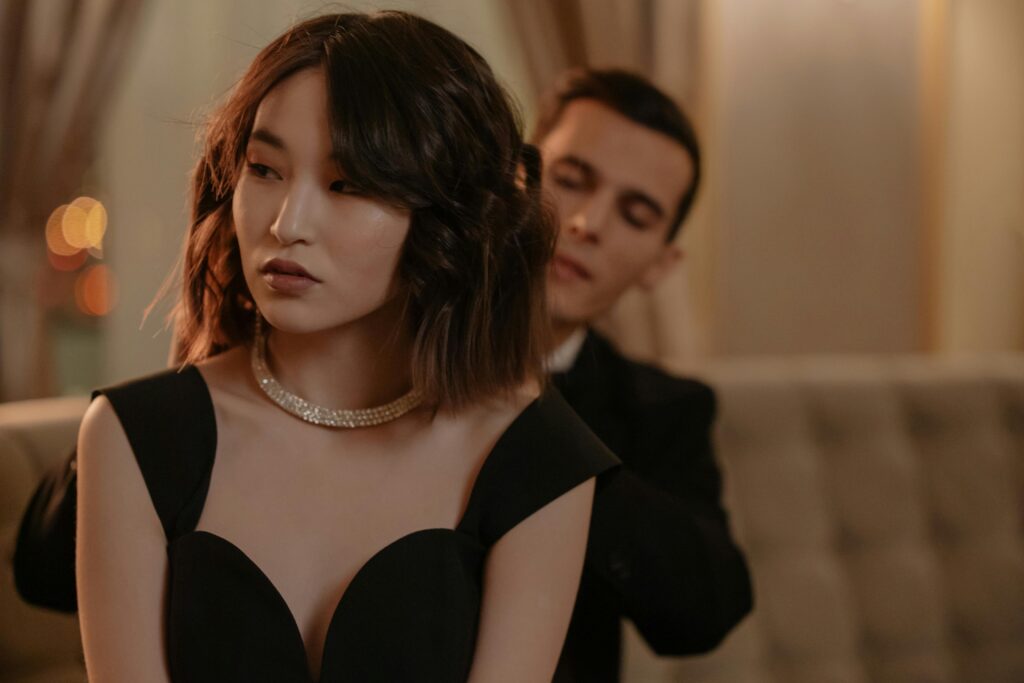 A stylish couple dressing up for a sophisticated event indoors with elegance and charm.